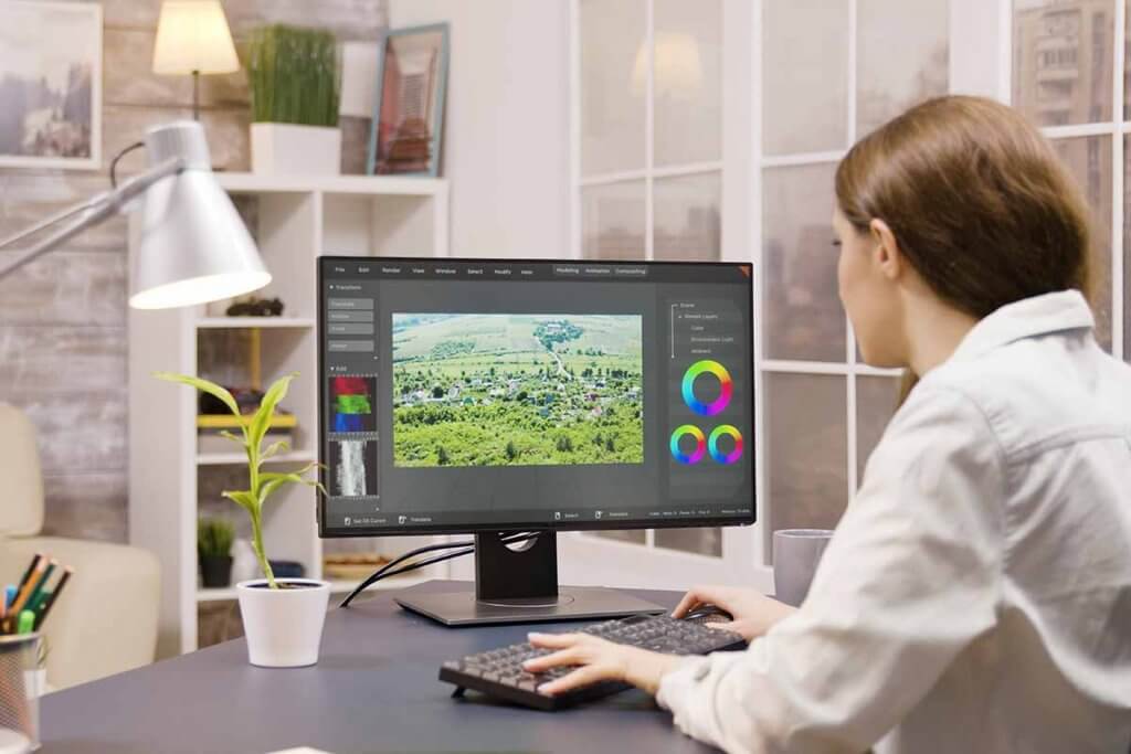 4k_monitor-junge_frau_sitzt_vor_4k_monitor_und_arbeitet_an_film
