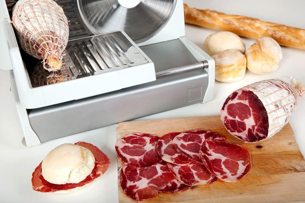 aufgeschnittene Wurst neben Allesschneider auf Tisch