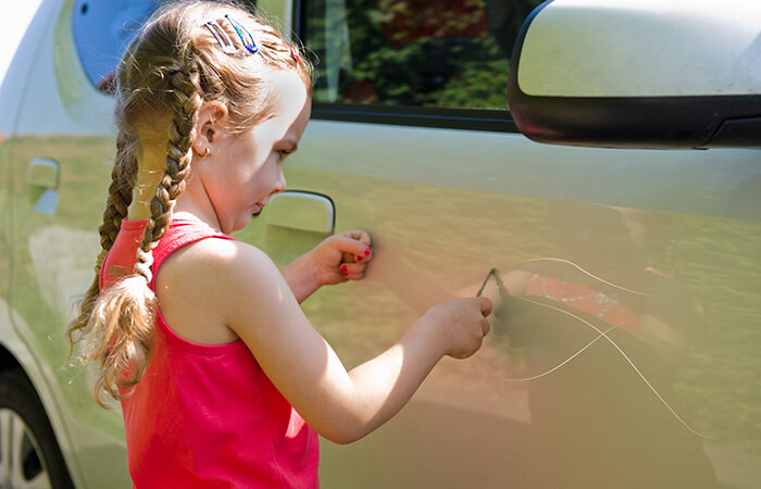 Kind zerkratzt Auto
