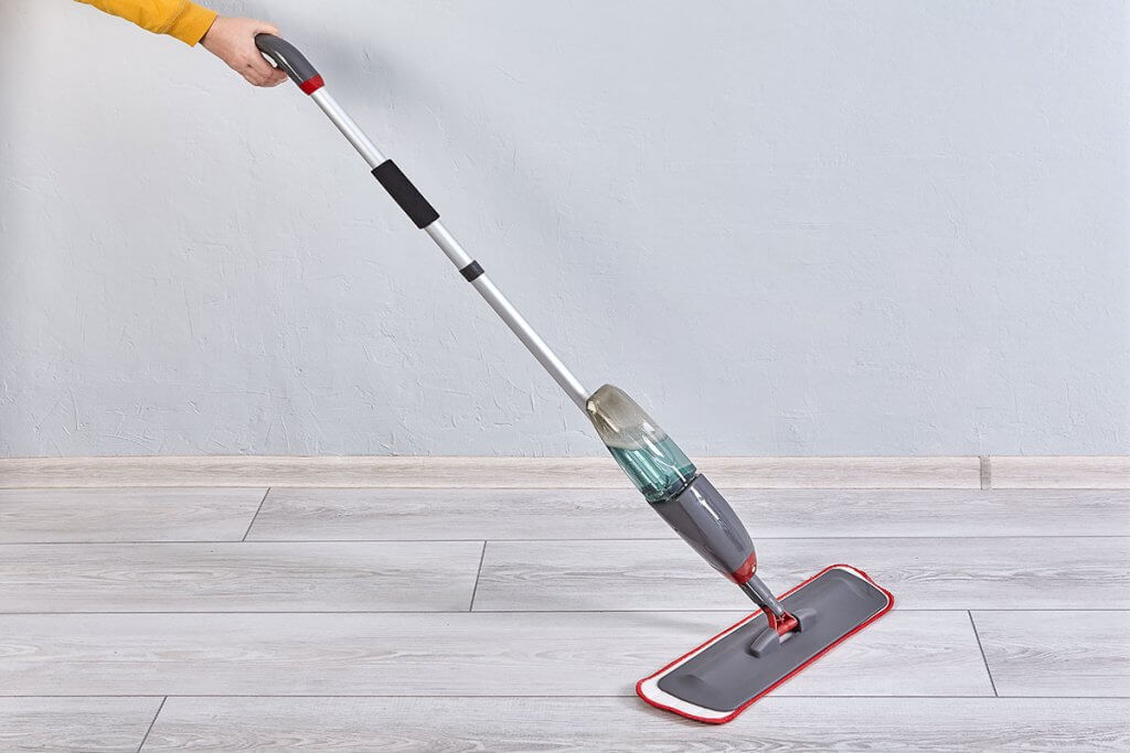 Boden wird mit Bodenwischer mit Spruehfunktion gereinigt