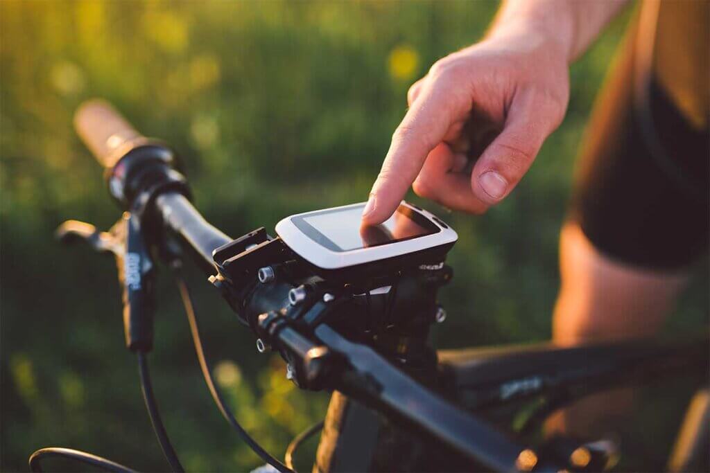 junger Mann stellt Fahrradcomputer am Fahrrad ein