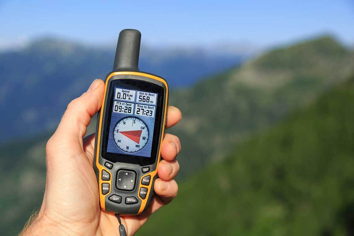 Mann haelt GPS-Geraet in Natur