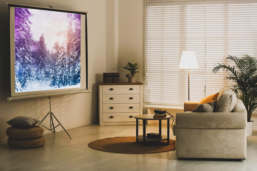 Beamer und Leinwand in gemĂŒtlichem Wohnzimmer