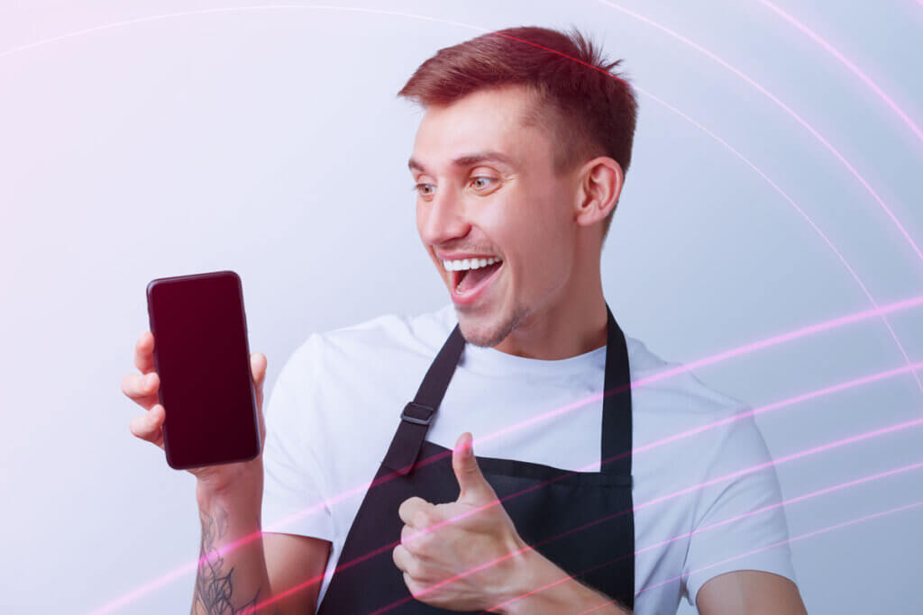 Mann freut sich ĂŒber Smartphone