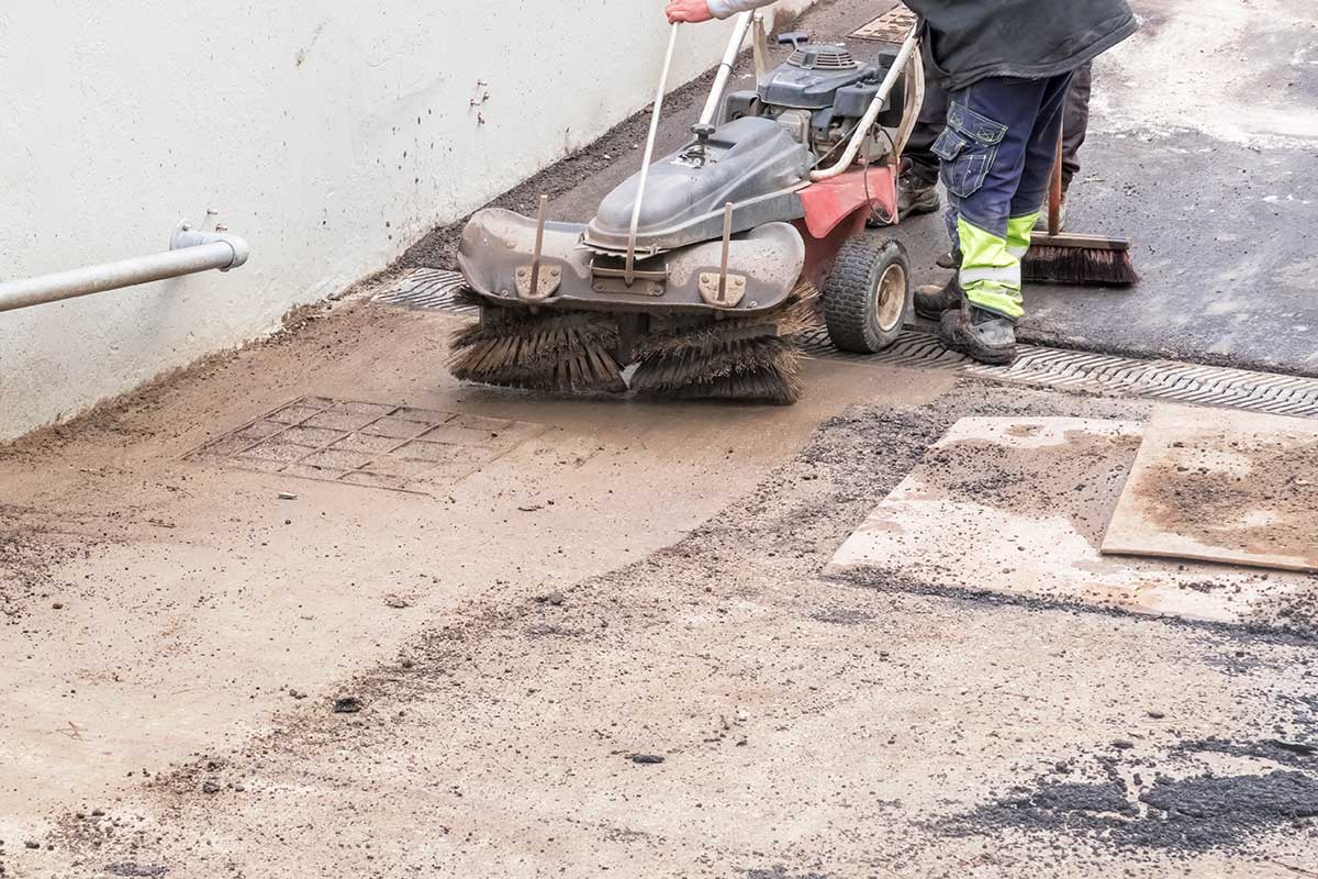Handkehrer reinigt StraĂe