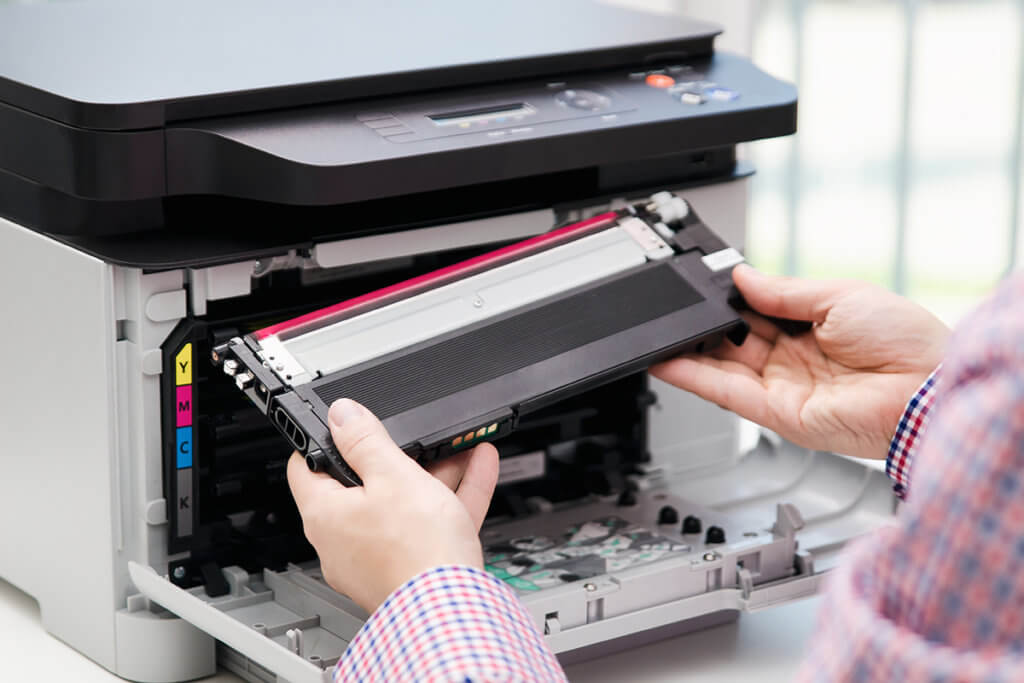 Mann ersetzt Toner in einem Multifunktionsdrucker.