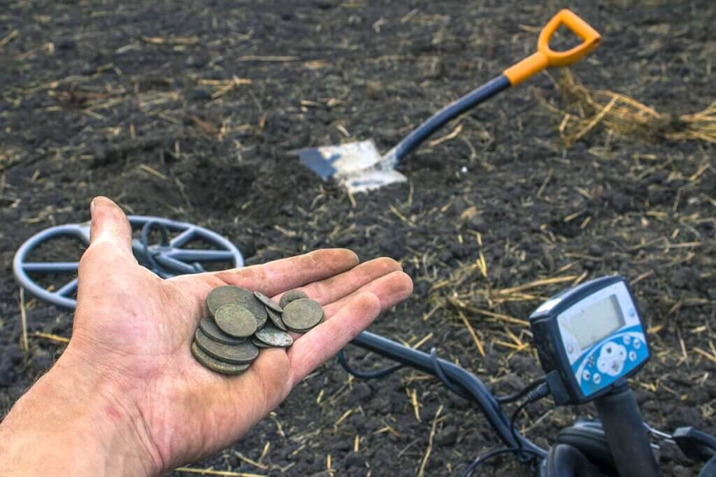 Mann hĂ€lt dreckige MĂŒnzen in Hand