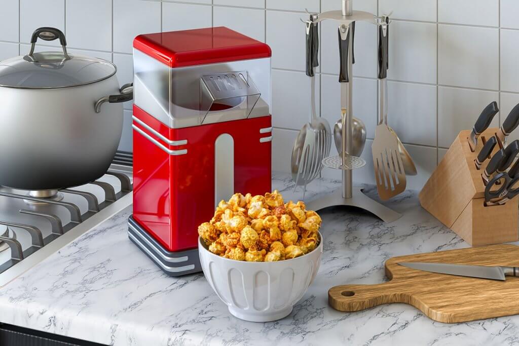 Popcornmaschine und Schuessel voller Popcorn stehen