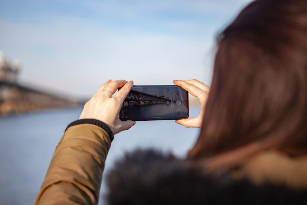 Frau fotografiert mit Smartphone