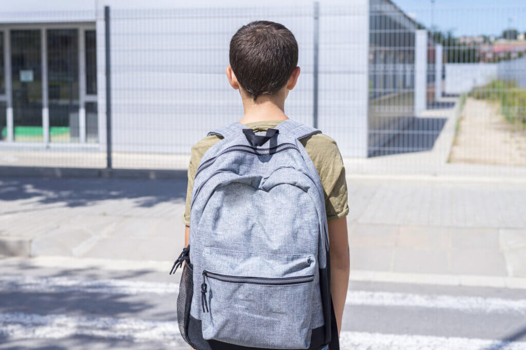 Teenager mit Schulranzen auf RĂŒcken