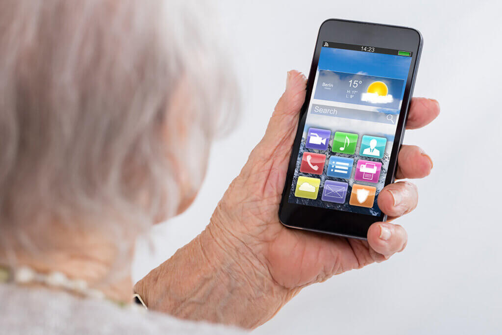 Ă€ltere Dame guckt auf ihr Handy