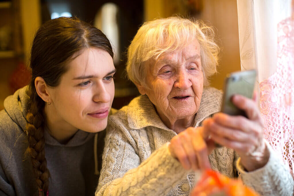 Ă€ltere Dame zeigt Frau etwas auf Smartphone