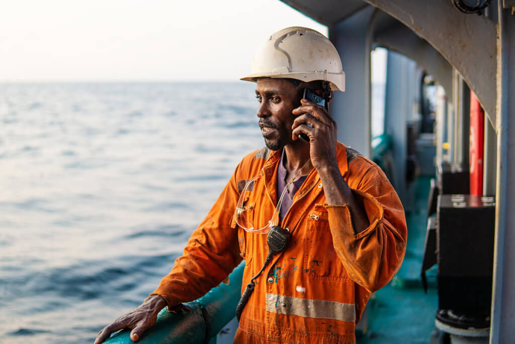 Mann auf Schiff nutzt Smartphone