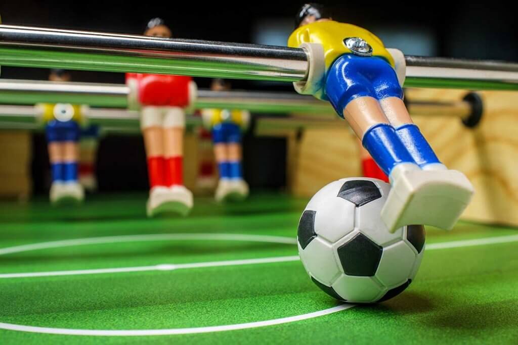 Kickerfigur schiesst Ball