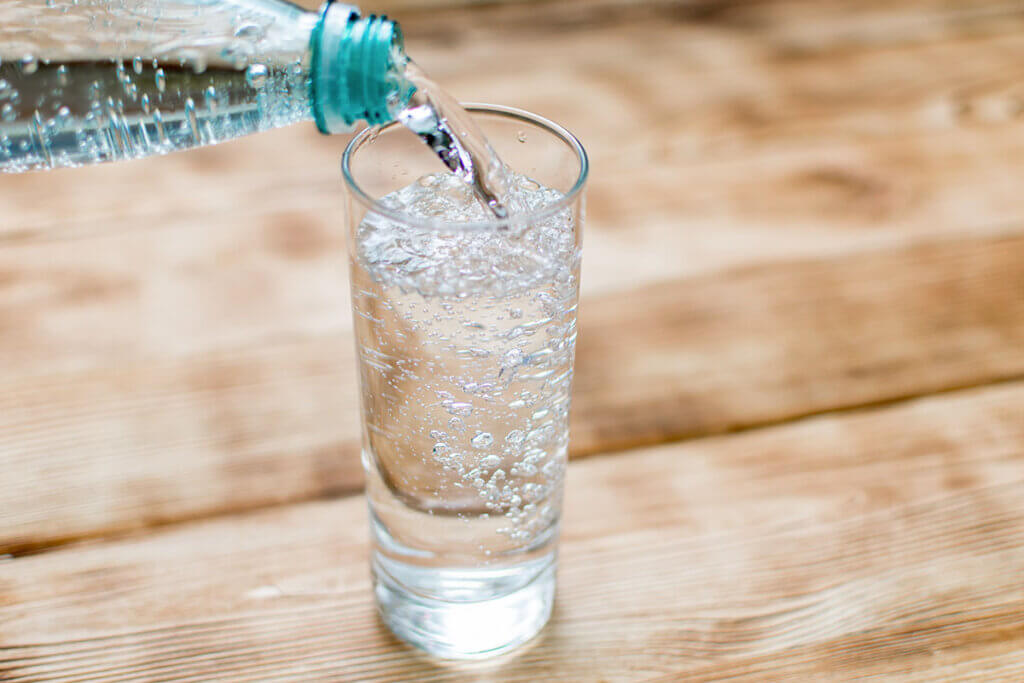 Sprudelwasser wird in GlÀser gegossen